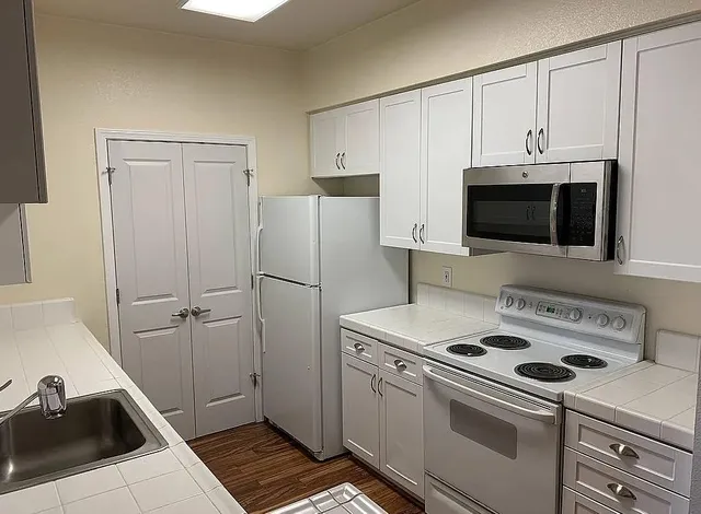 a kitchen with a refrigerator sink and stove top oven