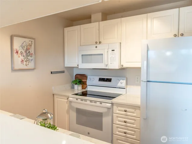 a kitchen with stainless steel appliances white cabinets and a refrigerator