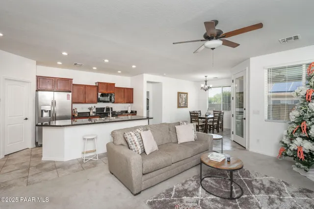 a living room with stainless steel appliances furniture and a view of kitchen