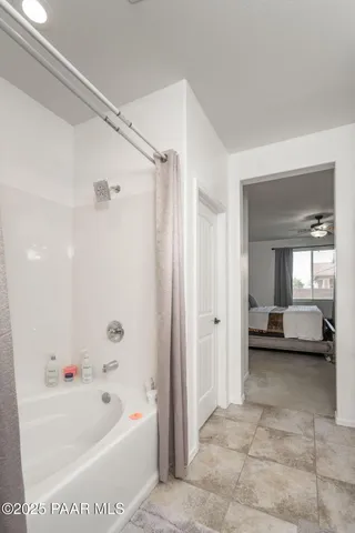 a bathroom with a tub shower and bedroom