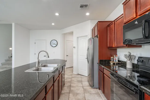 a kitchen with stainless steel appliances granite countertop a sink a stove and a refrigerator