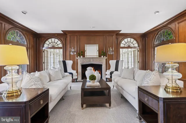 a living room with furniture fireplace and large windows