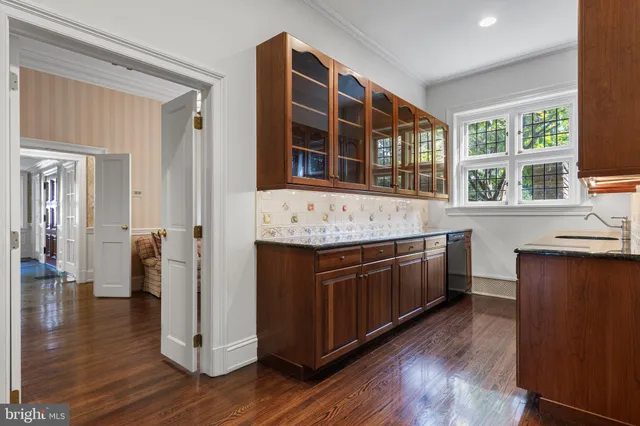 a kitchen with stainless steel appliances granite countertop a stove top oven a sink a dining table and chairs