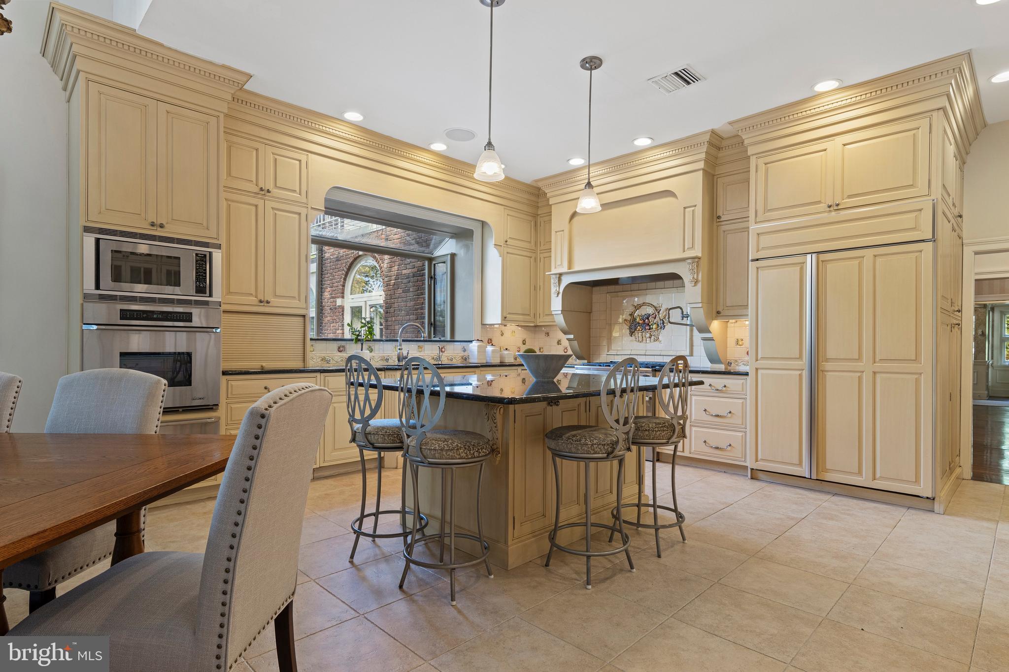 717 North Spring Mill Road Villanova, PA 19085 - Photo 22 of 62 a kitchen with stainless steel appliances granite countertop a stove top oven a sink a dining table and chairs