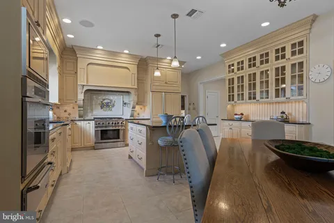 a very nice looking open dining room with a large window and chandelier