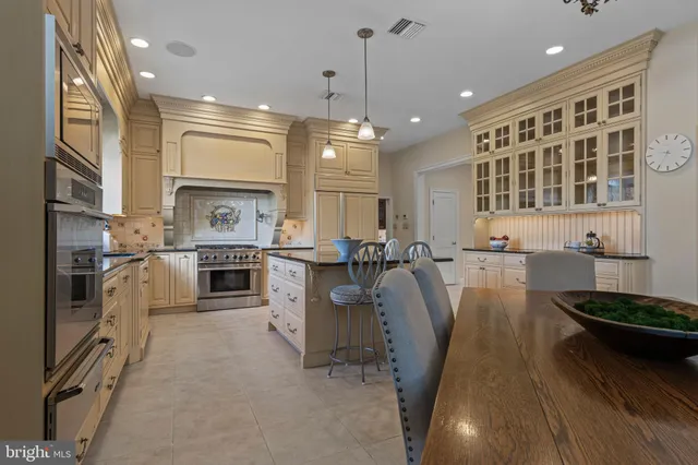 a very nice looking open dining room with a large window and chandelier