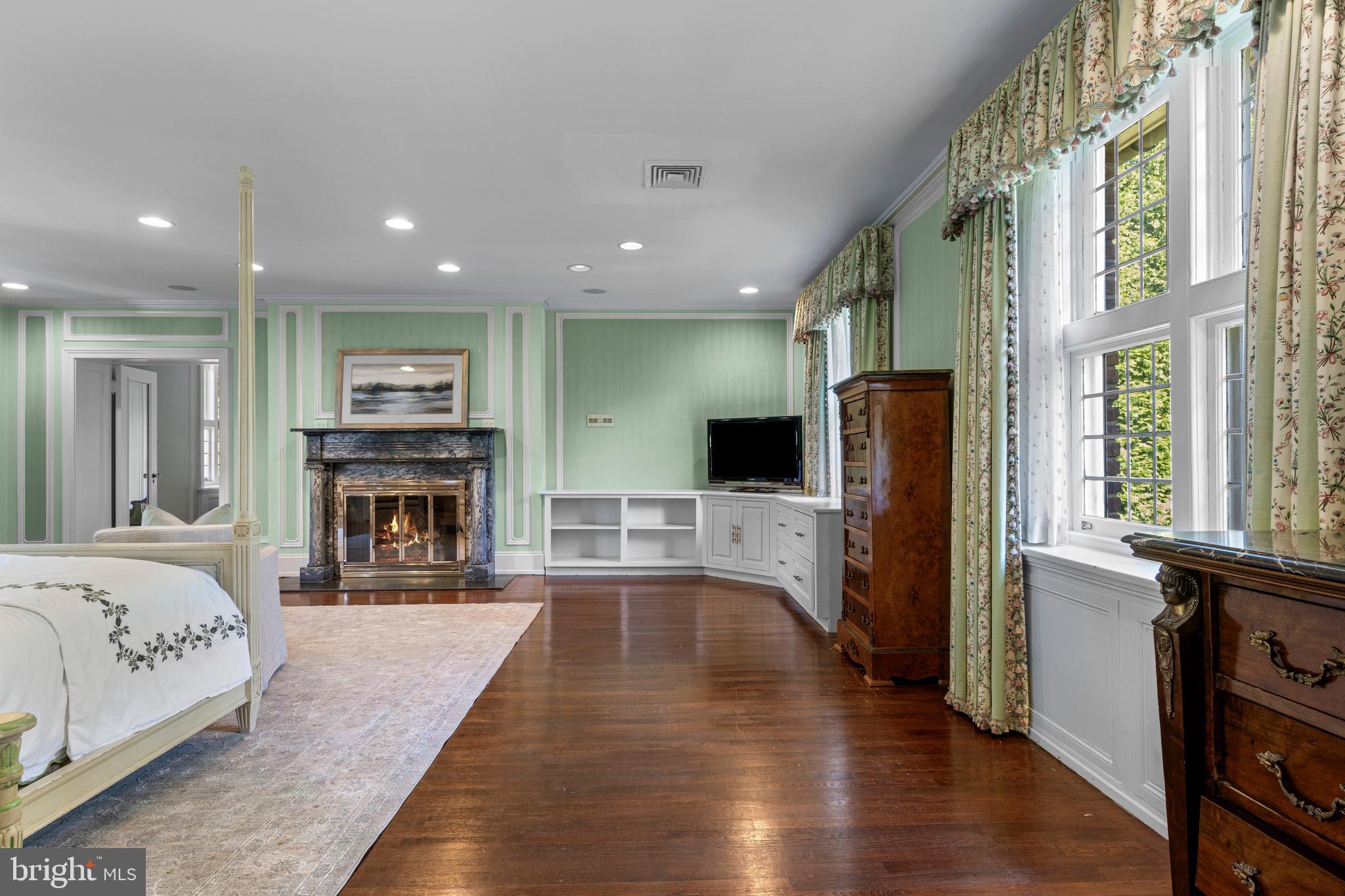 717 North Spring Mill Road Villanova, PA 19085 - Photo 37 of 62 a view of a living room kitchen with a flat screen tv and a fireplace