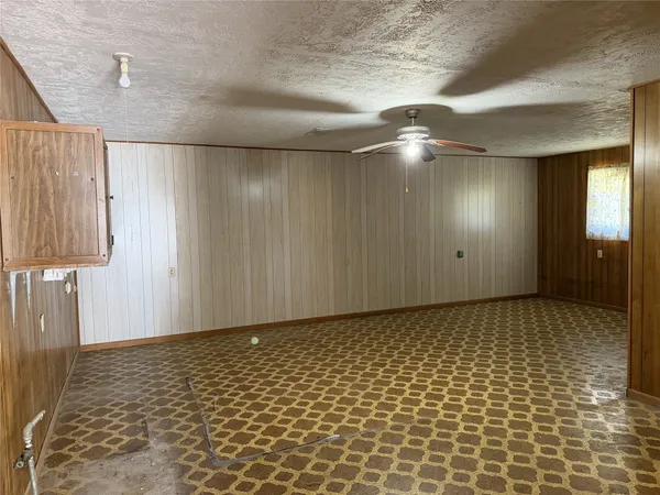 en empty room with window and wooden floor