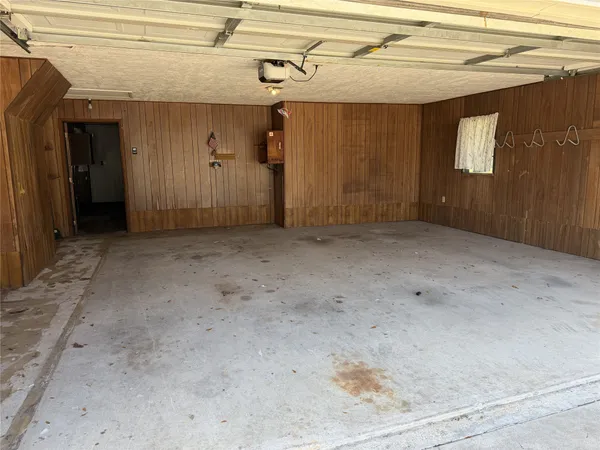 a view of a house with a yard fire pit and a large tree