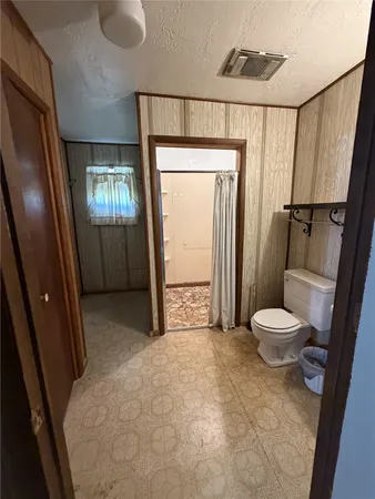 a bathroom with a toilet and a shower