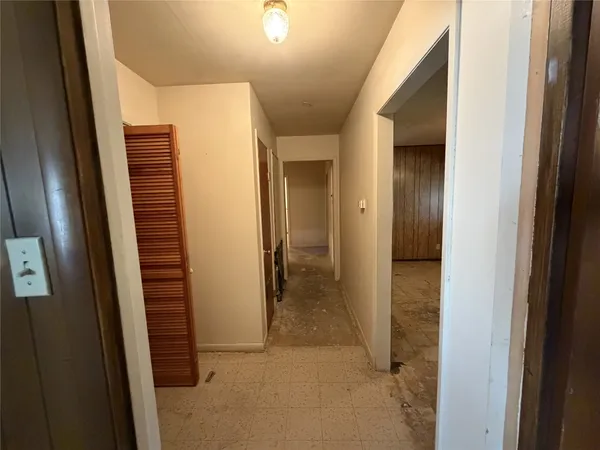 a view of a hallway with wooden cabinets