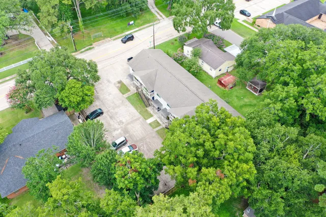 an aerial view of a house with a yard and trees