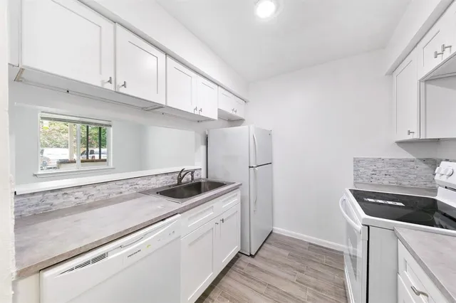 a kitchen with granite countertop cabinets stainless steel appliances and a wooden floor