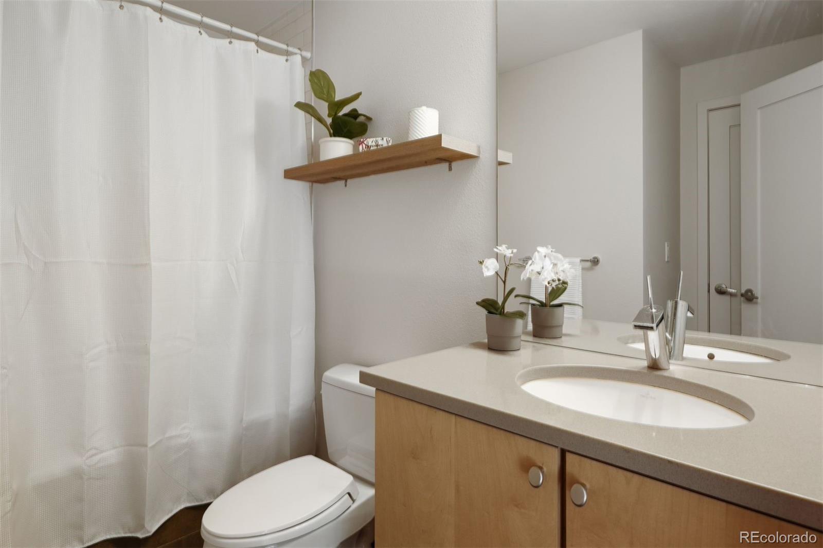 360 South Lafayette Street, Unit 301 Denver, CO 80209 - Photo 20 of 29 a bathroom with a sink a toilet and mirror