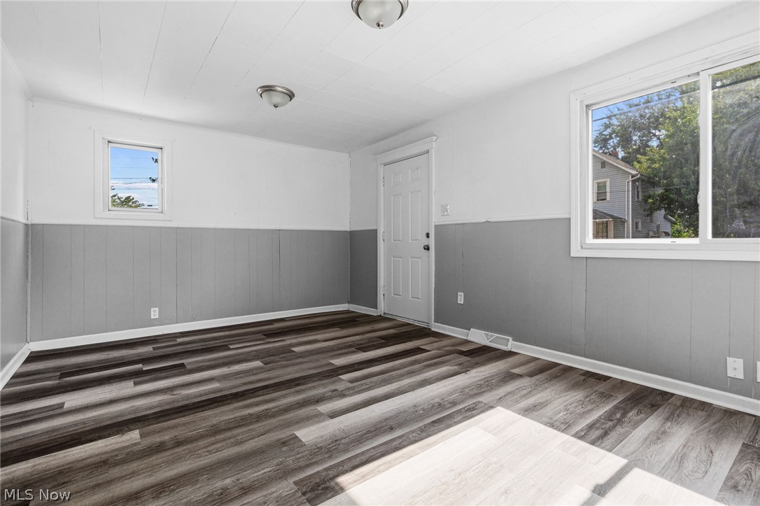 2387 29th Street Southwest Akron, OH 44314 - Photo 6 of 24 Spare room with wainscoting, dark wood finished floors, and wooden walls