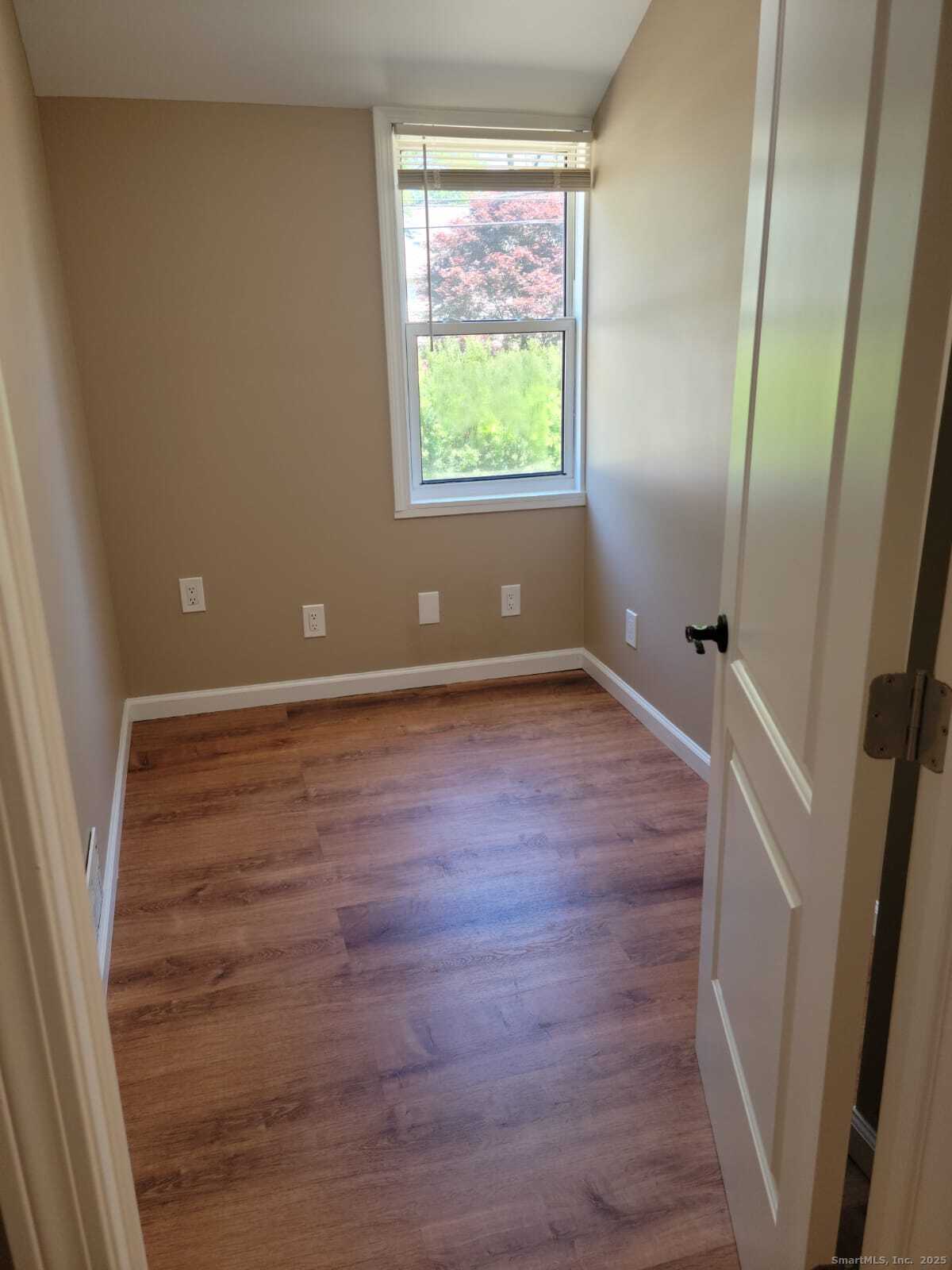 62 High Ridge Drive Bridgeport, CT 06606 - Photo 11 of 14 an empty room with wooden floor and windows