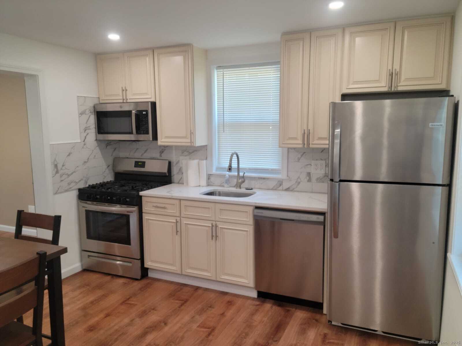 62 High Ridge Drive Bridgeport, CT 06606 - Photo 4 of 14 a kitchen with stainless steel appliances granite countertop a refrigerator a stove a sink and a microwave
