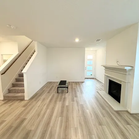 a view of empty room with wooden floor and fireplace