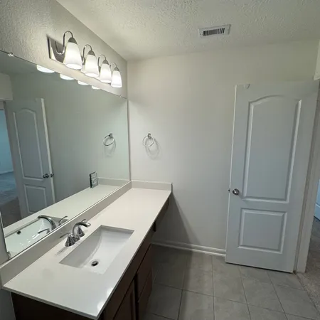a bathroom with a sink vanity and a mirror