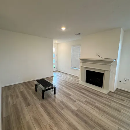 a view of an empty room and wooden floor fire place