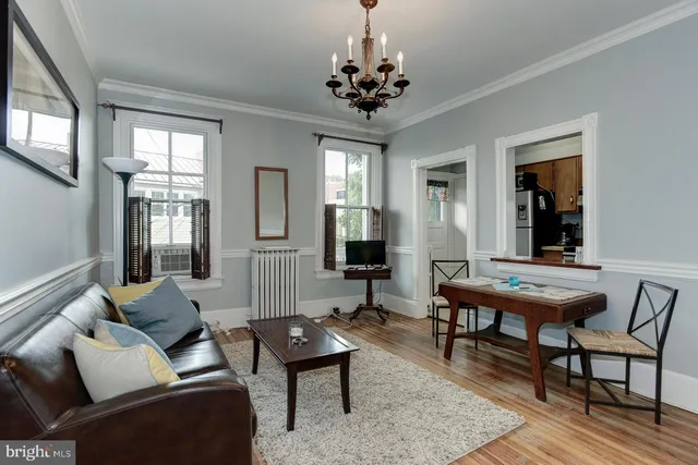 a living room with furniture and a chandelier