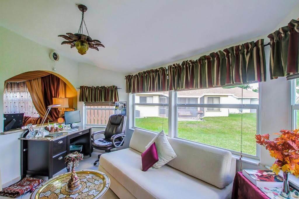 9709 Sunny Isle Circle Boca Raton, FL 33428 - Photo 13 of 21 a living room with furniture fireplace and a large window