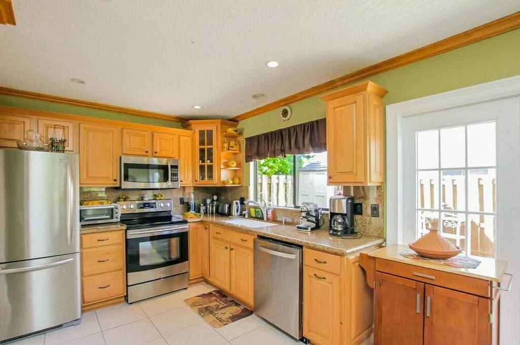 9709 Sunny Isle Circle Boca Raton, FL 33428 - Photo 2 of 21 a kitchen with stainless steel appliances granite countertop a stove a sink dishwasher a refrigerator and a microwave oven with granite countertops