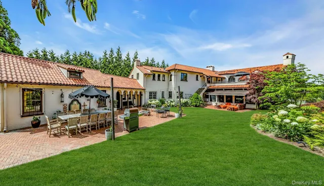 a front view of a house with garden and sitting area