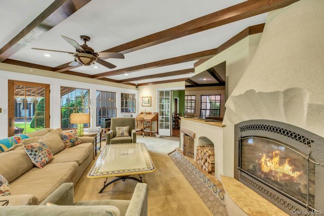 a living room with fireplace furniture and a floor to ceiling window
