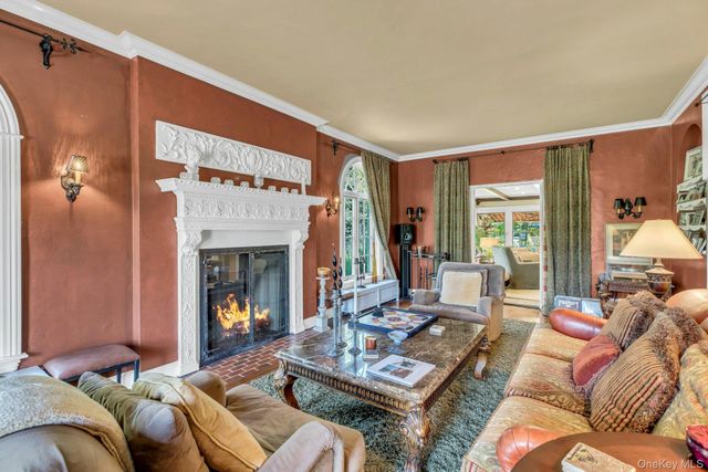 a living room with furniture a large window and a fireplace