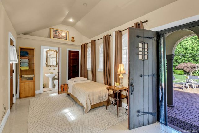 a spacious bedroom with a bed and a large mirror