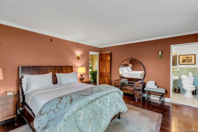 a bedroom with a bed a table and painting on the wall