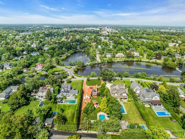an aerial view of residential houses with outdoor space and lake view