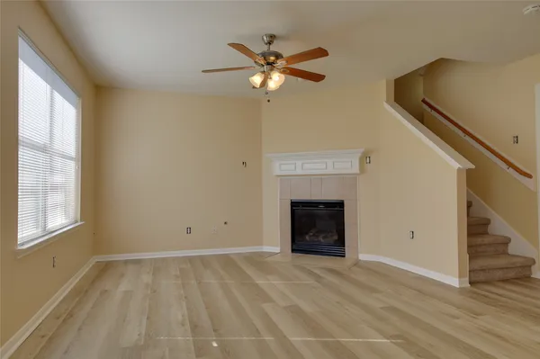 a view of an empty room with a fireplace and a window