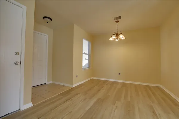 a view of a room with wooden floor and chandelier