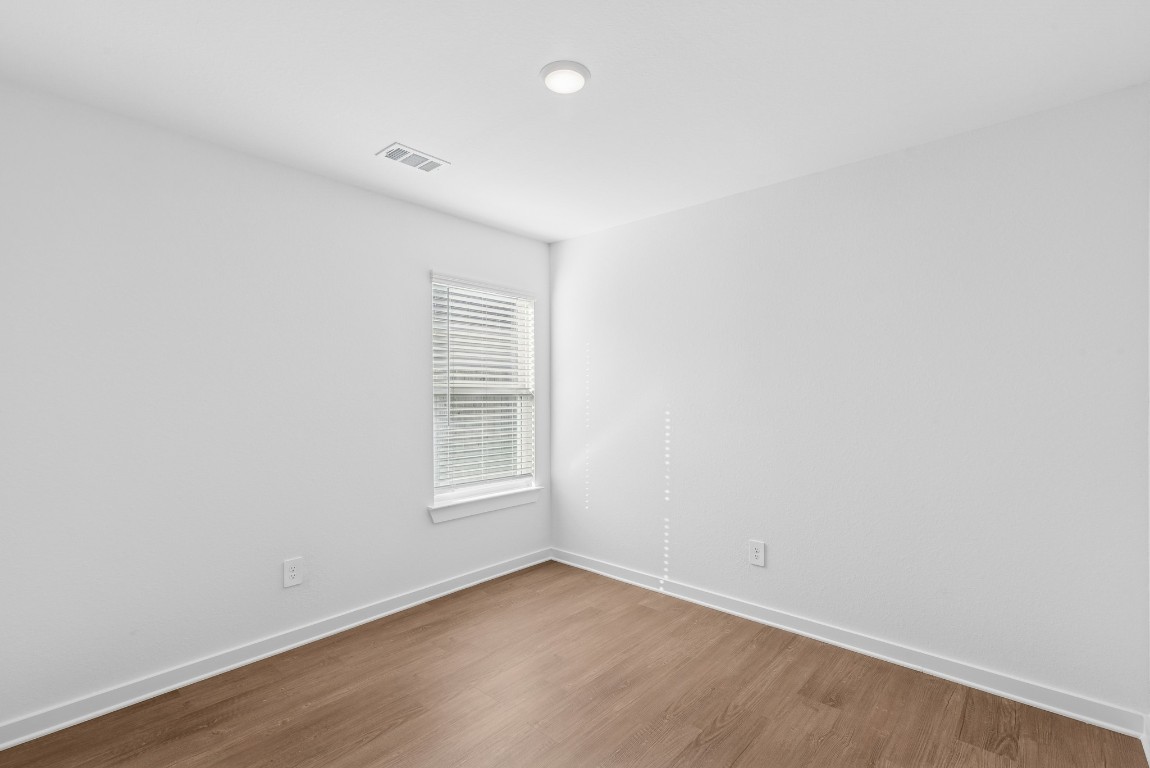 707 Hackberry Branch Magnolia, TX 77354 - Photo 43 of 50 an empty room with wooden floor and windows