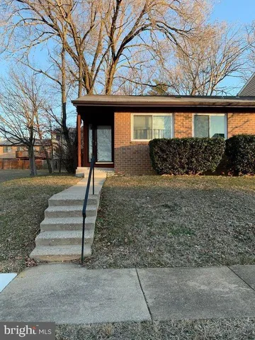 a front view of a house with garden and plants