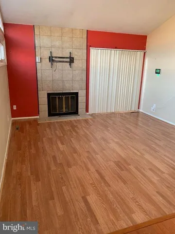 a view of an empty room with a fireplace and a window