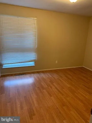 a view of a room with wooden floor and a window