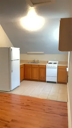 a view of a kitchen with wooden cabinet and a refrigerator