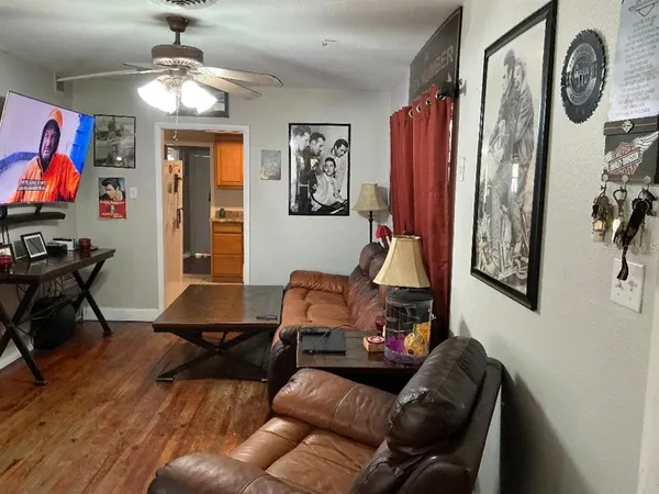 a living room with furniture a flat screen tv and a wall paintings
