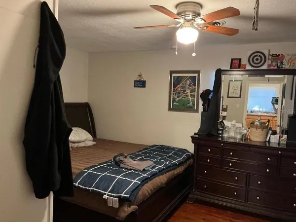 a bedroom with a bed and a mirror on the dresser