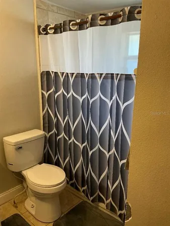 a white toilet sitting next to a shower curtain