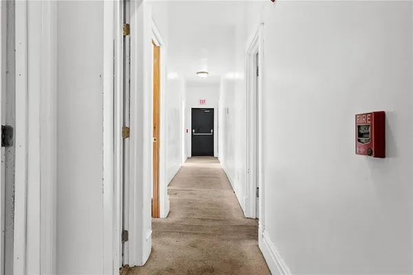 an empty room with windows and fireplace