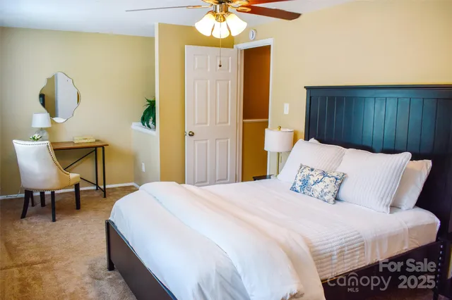 a bedroom with a bed table and chair