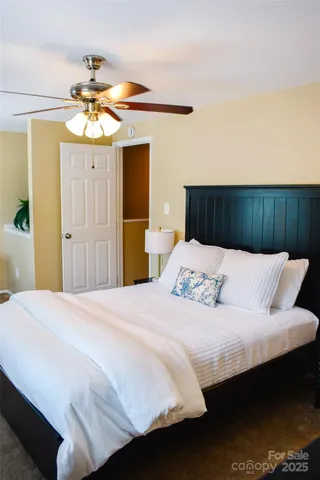 a bedroom with a large bed and a chandelier
