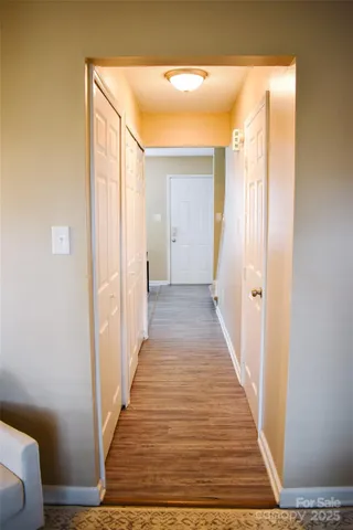 a view of a hallway with wooden floor