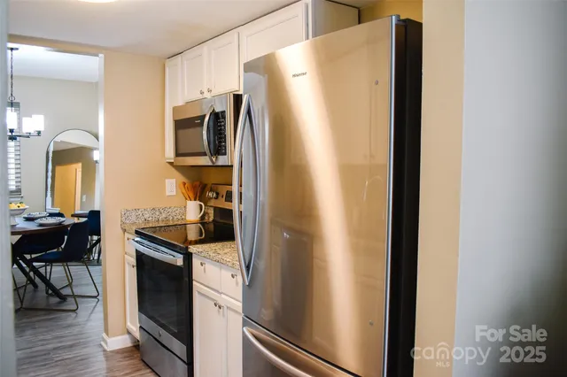 a kitchen with stainless steel appliances granite countertop a refrigerator and a stove