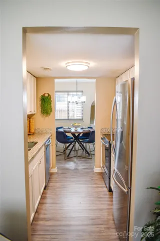 a living room with stainless steel appliances furniture a rug and a large window