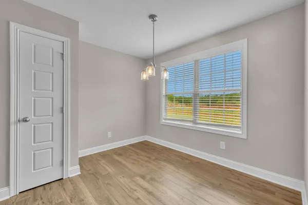 an empty room with a ceiling fan and a window